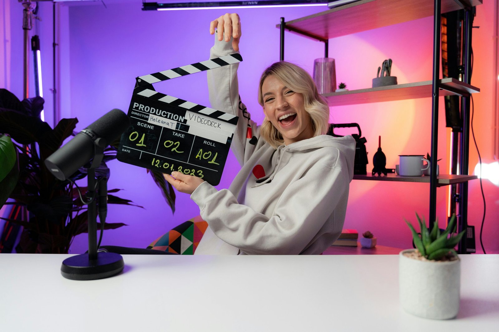 a woman holding a clapper in front of a camera